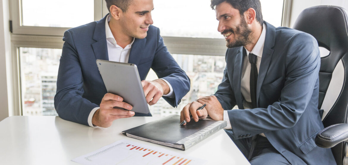 male-employee-showing-his-partner-digital-tablet-meeting